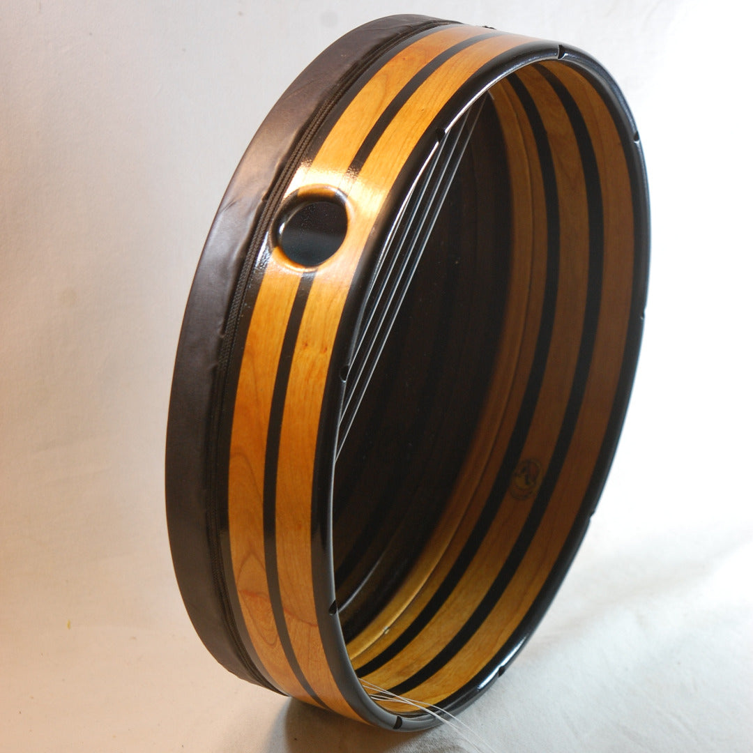A side view of a Bee Mythos Bendir drum showing the distinctive 'bee stripe' finish and black colored cording.