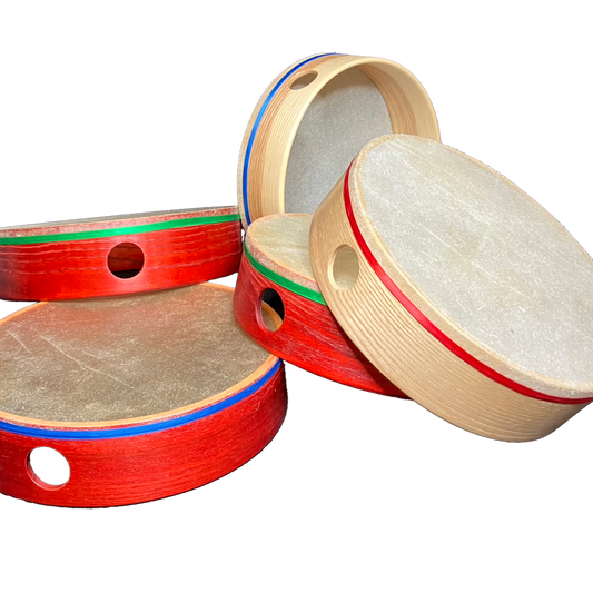 A set of frame drums in various sizes with a natural skin head and a colorful satin ribbon around the seam where the head and shell meet.